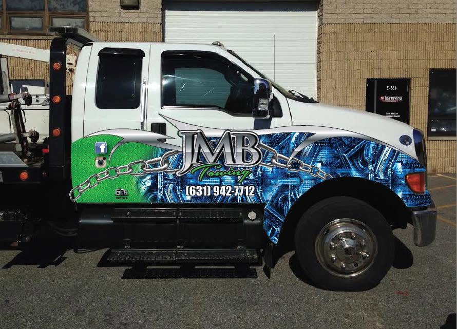 JMB Towing truck with custom graphics and phone number on the door